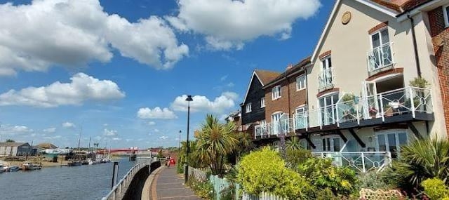 A coastal town in West Sussex with affordable housing options and a range of amenities, including a high street with shops and restaurants, a leisure centre, and a train station