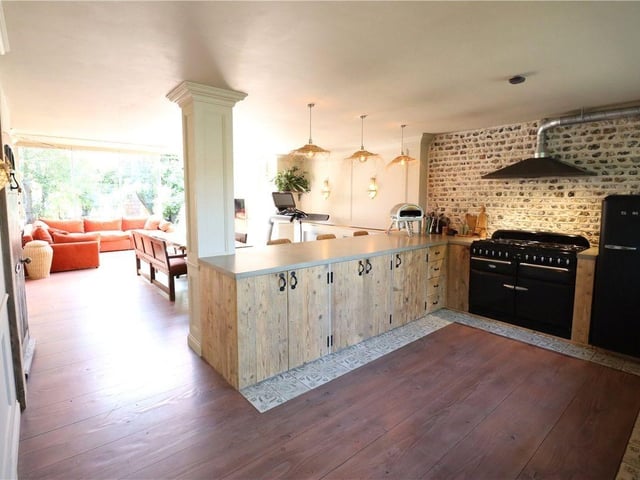 The front door opens into the kitchen, with polished concrete worktops and striking exposed flint brickwork