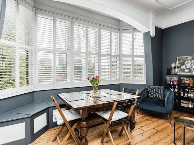 The main reception room has a large open fire place and a bay window