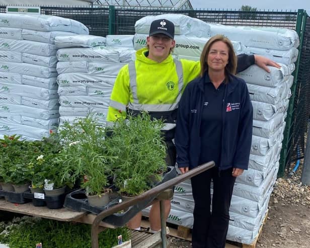 Alison Finneran from Blind Veterans UK accepts plant donation from young Oscar at Ferring Nurseries