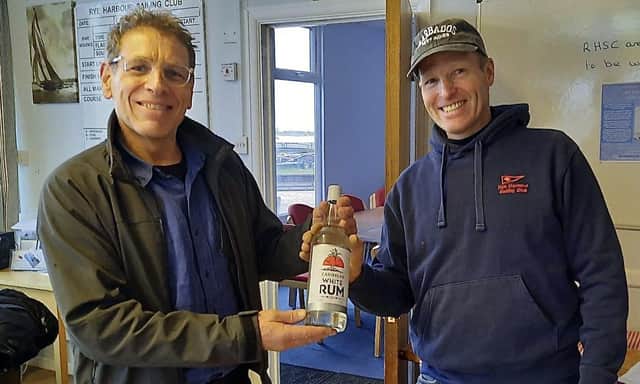 Hugh Ashford (left) receives his Rum Race winner's prize from Simon Marsh, Rear Commodore (Dinghies), Rye Harbour SC.