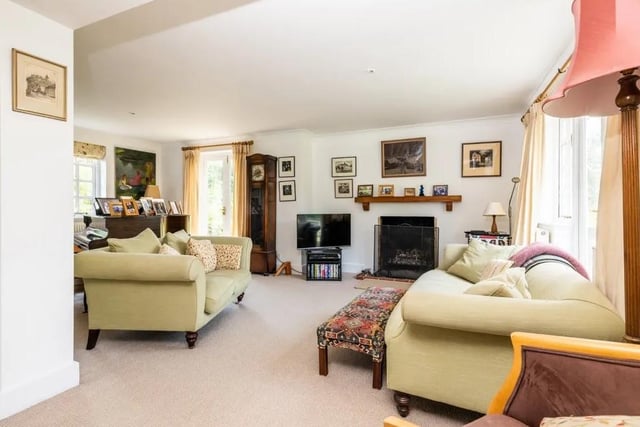 The large, triple aspect sitting room has a fireplace and French doors on two sides