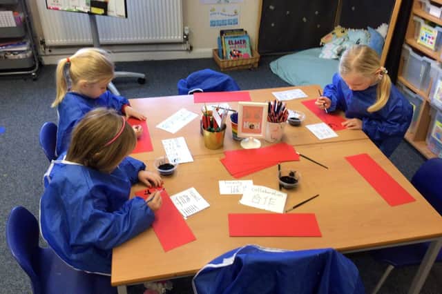 Year-one pupils at Thomas A'Becket Infant School practising Chinese writing