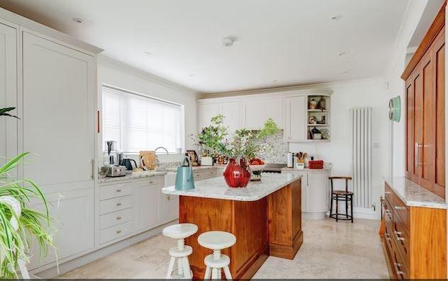 The kitchen/dining room has an extensive range of base and wall units and working surfaces, with a central island and appliance space. There is a separate utility room and downstairs cloakroom.