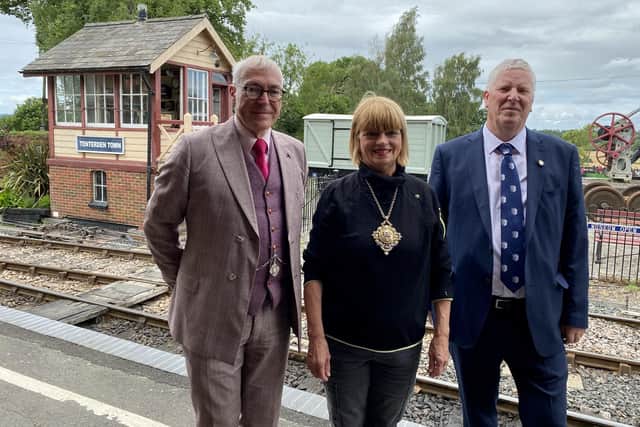 From left, General Manager Robin Coombes; Tenterden Mayor  Sue Ferguson and Coronation-appointed Baron of the Cinque Ports, Tenterden, John Crawford, standing on the  station platform with the former Chilham signal box visible behind them.