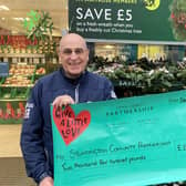 Storrington neighbourhood warden Chris Poore receives a cheque from Waitrose towards funding of next year's village fun day