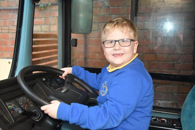 An enthusiastic pupil takes the wheel of the new bus