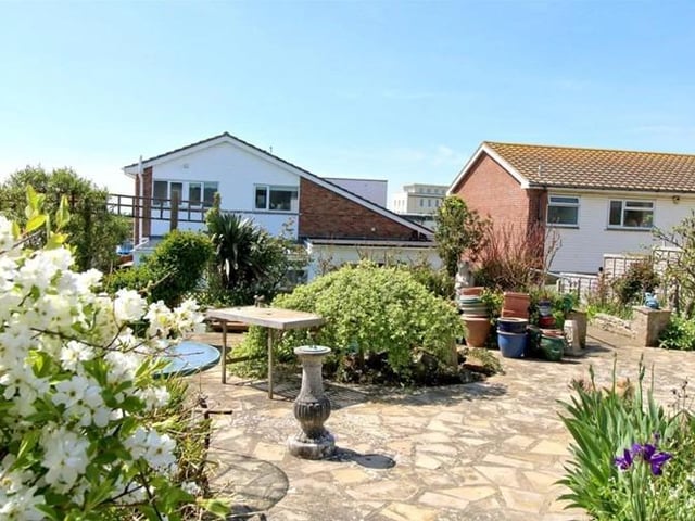 In the garden the decked area leads to an artificial lawn and steps down to swimming pool. The steps lead up to a patio area with mature planting, with decking next to a timber studio, a rockery with a pond and a bank with wildflower planting.