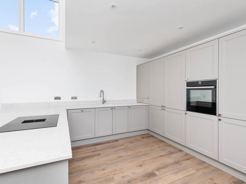 The contemporary kitchen has a breakfast bar area, stone work tops and integrated appliances