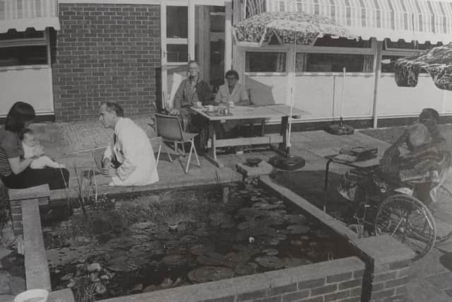 Dr Alan Kingsbury with visitors relaxing by the fish pond at the hospice in Columbia Drive. Picture: St Barnabas House