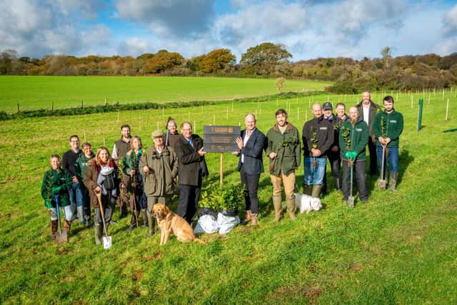 Rupert Green and Henry Green holding a commemorative plaque, together with members of the Green family and Covers staff who planted trees at Selhurst Park near Chichester