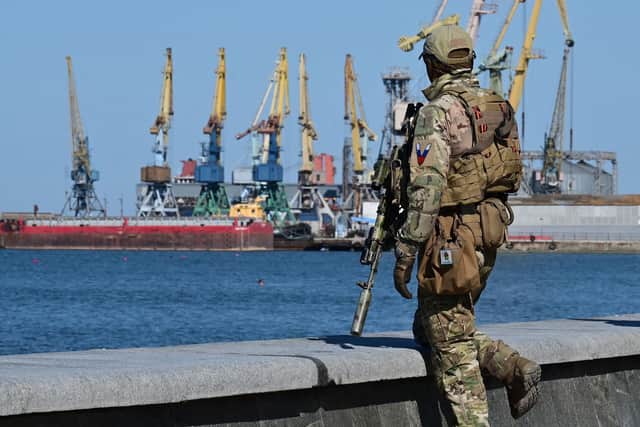 A Russian serviceman patrols on the promenade in Berdyansk, amid the ongoing Russian military action in Ukraine, on June 14, 2022. (Photo by YURI KADOBNOV/AFP via Getty Images)