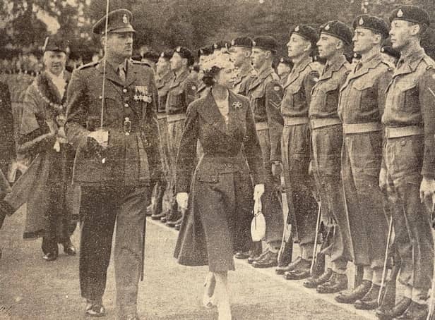 The Queen inspects a military guard of honour in Priory Park.