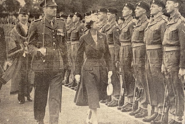 The Queen inspects a military guard of honour in Priory Park.