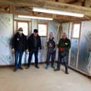 The team relaxes after completing insulation of the small workshop.