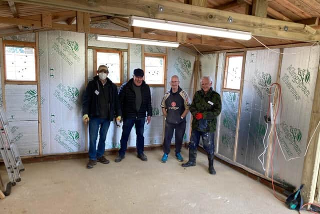 The team relaxes after completing insulation of the small workshop.