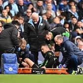 Brighton's Solly March is stretchered off the pitch at Manchester City
