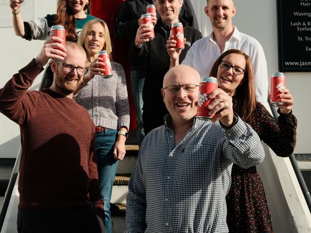 Team PRG raising a can to celebrate 45 years in business.