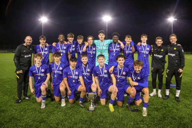 Bexhill Men's Football Academy 1st Team with coaches Sean Noble (left), Matt Simpson (second from right), and Ben Ferguson (right) with the county cup.