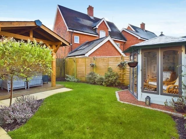 The south facing rear garden is a lovely size, with a generous covered patio, an expanse of lawn and beautifully kept borders. There is also a gated side access and a lovely summer house
