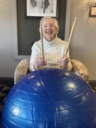 Earlsfield Court resident, Jean, enjoying the care home's first Drum Fit class.