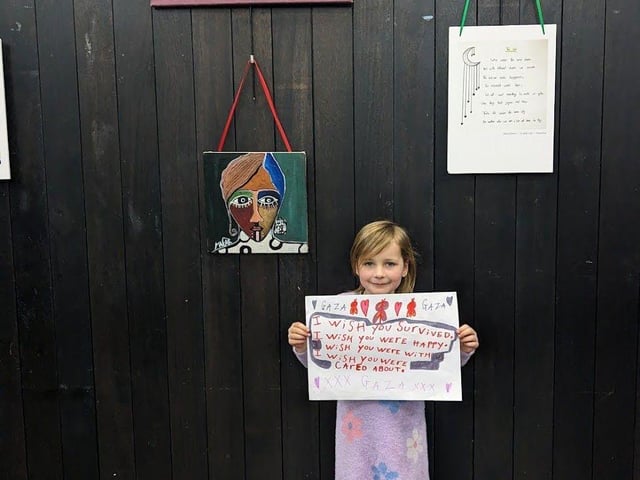 Young visitor with competition entry at Oh Moon Tell me Truth Exhibition at Stade Hall - February 2024