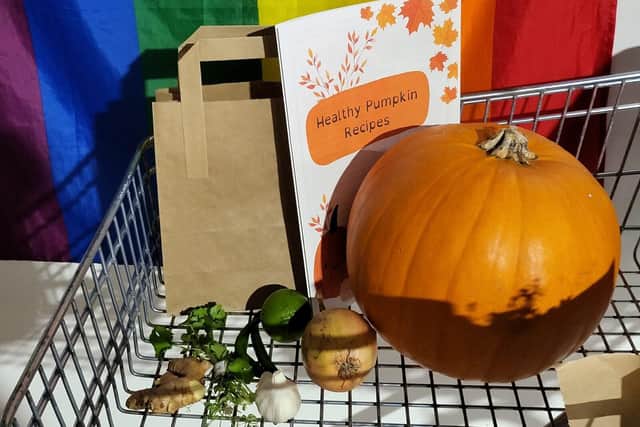 A paper bag, pumpkin recipe book and various vegetables including a pumpkin given out to attendees. 