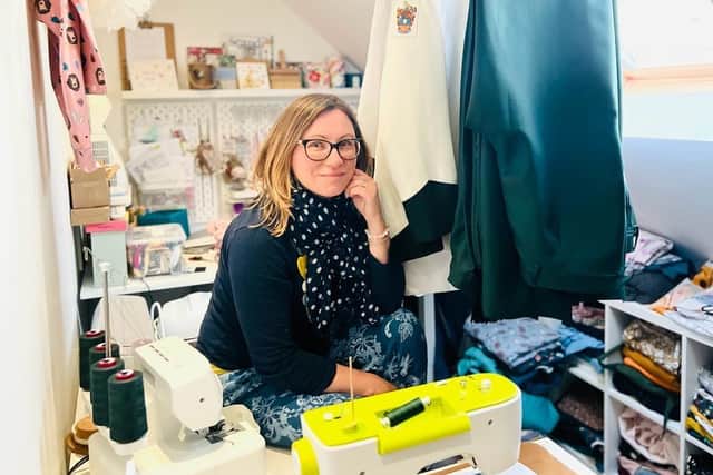 Angelika in her sewing workshop with some of the freshly made uniforms.