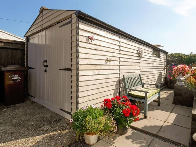 A gated driveway is located to the side of the property, providing access to the garage.