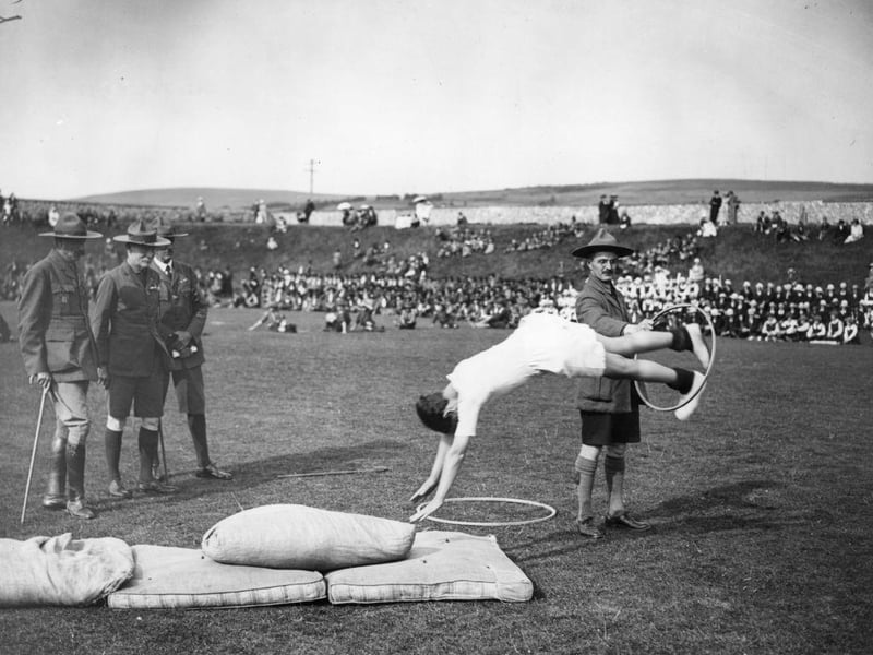 Robert Baden Powell, founder of the Scout Movement and Chief Scout, takes an interest in a display of tumbling at a Grand Rally of Scouts and Guides at Lewes on 13th July 1922.