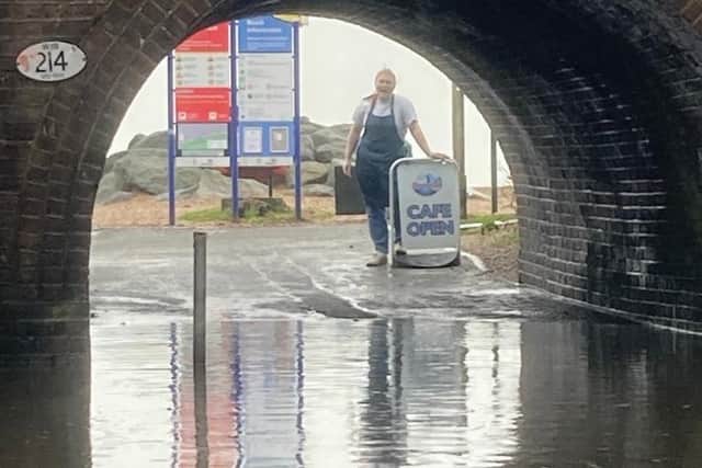 Phoebe Crummy, who works at Oceanside Cafe, by the flooded underpass