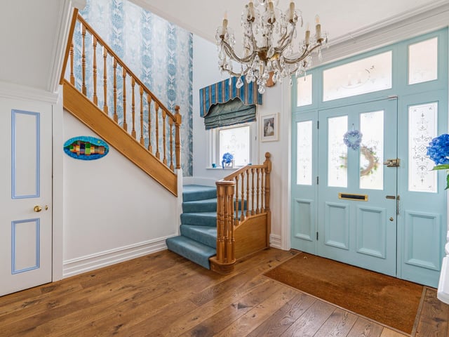 There is an entrance hall with a feature staircase and wooden floors
