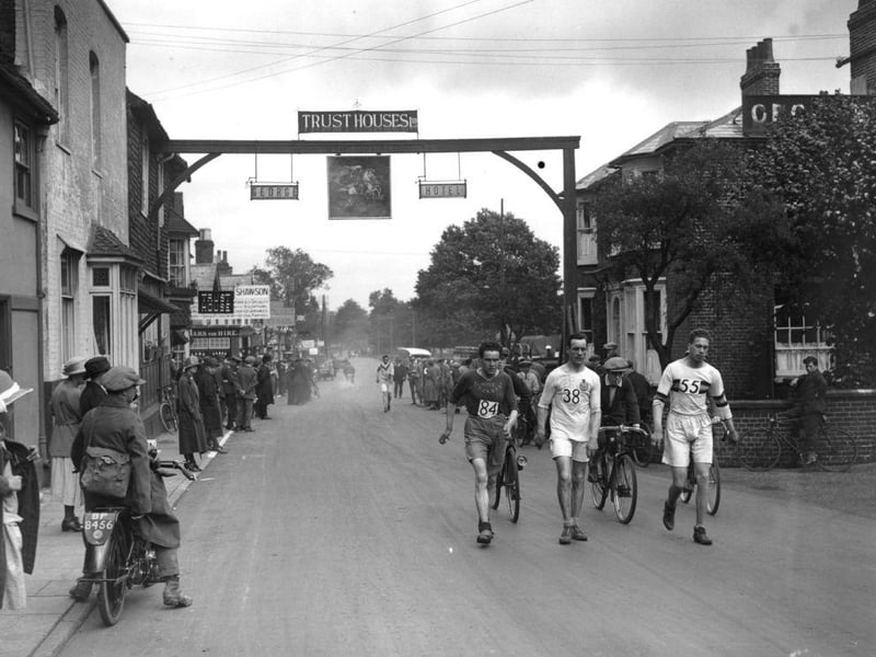 A crowd of locals turns out to watch as competitors pass through Crawley, on the Surrey Walking Club' annual London to Brighton walk on 13th September 1924:
