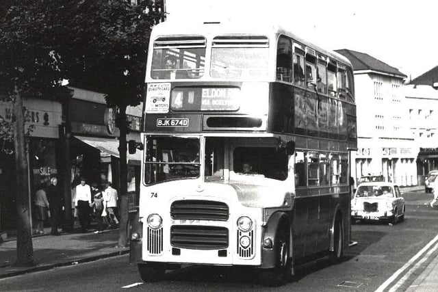 This image is of an Eastbourne Corporation bus travelling up Terminus Road when the road was two-way traffic. On the left are shops called Meakers, a gents outfitters, and Dorothy Perkins, ladies clothing. They were demolished to make way for the entrance to the Arndale Centre, now the Beacon.