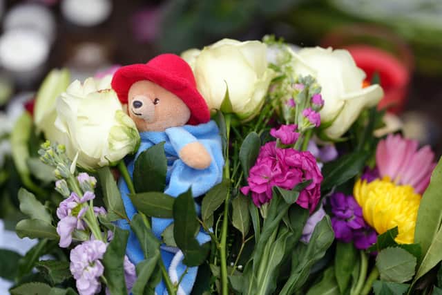 Flowers and a Paddington Bear teddy are laid outside of Windsor Castle, Berkshire, following the death of Queen Elizabeth II on Thursday. Photo: John Walton/PA Wire