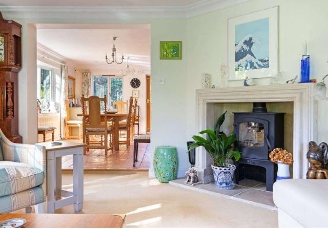 There is a stone fireplace in one corner of the sitting room, set with a woodburner.