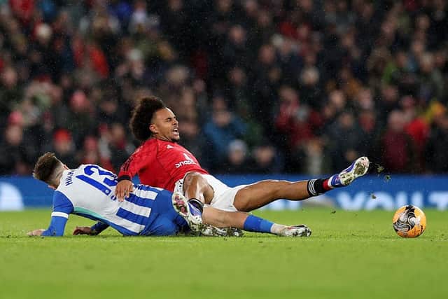 Manchester United forward Joshua Zirkzee is tackled by Brighton's Jack Hinshelwood during the Emirates FA Cup third round match at Old Trafford. (Photo by Jan Kruger/Getty Images)