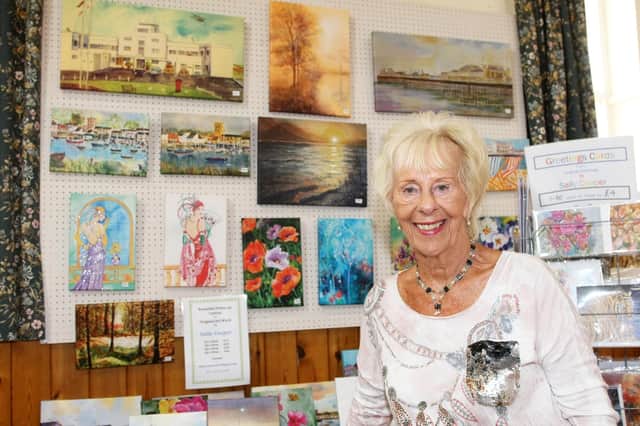 Sally Cooper at the festival in 2019 with her striking paintings and cards that have been part of it since the start, more than 50 years ago. Picture: Derek Martin DM1980078a