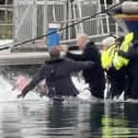 Still from footage depicts James Corden falling into water whilst filming in Eastbourne's Sovereign Harbour. // James Corden falls into the harbour filming for new Apple TV comedy series 'The Choir' with Ruth Jones.