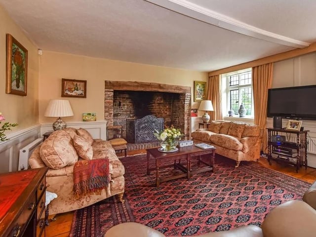 There is a large drawing room with an impressive inglenook fireplace