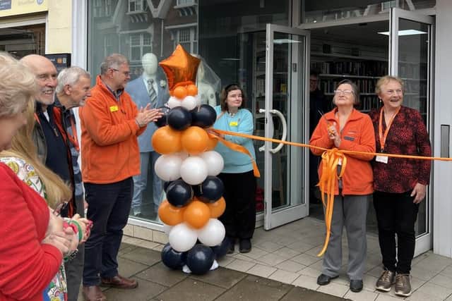 Longest serving volunteers, Annie and Margaret, cut the ribbon to declare the shop open.