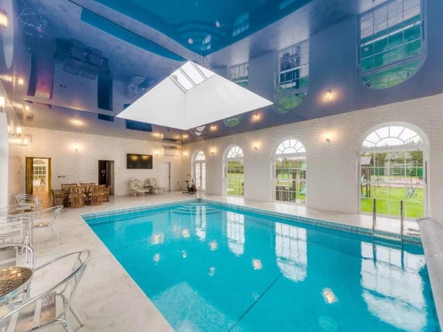 This six bed detached house is on the market with Strutt & Parker for £9,000,000. This new build was completed in 2013 also has six baths, six receptions. Outside there are tennis courts, summer house, gardener’s store, two triple garages and a swimming pool.