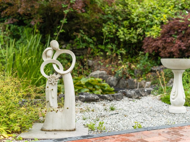 The gardens feature lawns, flowerbeds and borders, and there is a large paved terrace at the back of the house