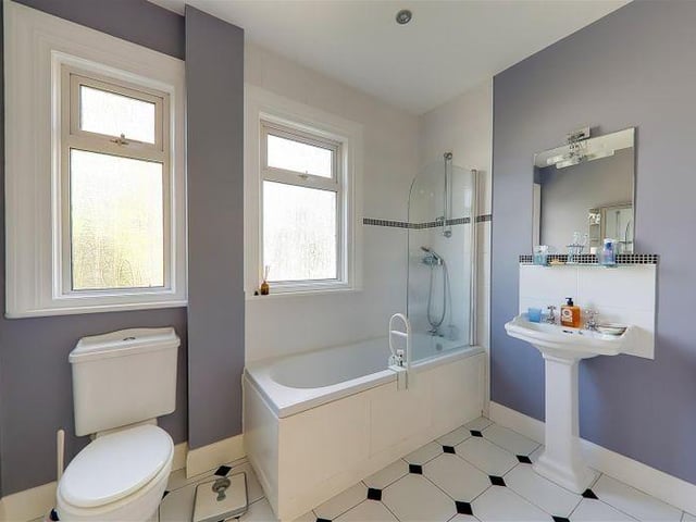 One of three three bathrooms, with a modern suite  and vertical chrome towel rail