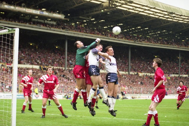 Bruce Grobbelaar punches a high ball clear of Kevin Ball and Gordon Armstrong in the 1992 FA Cup Final.