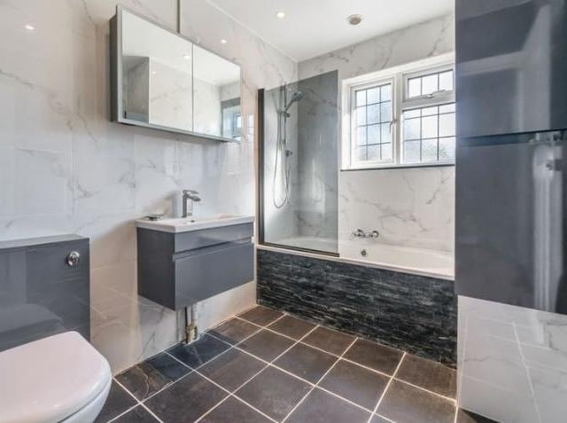 The property has two modern bathrooms, to the rear of one is a bath with overhead shower, sink with storage unit below, mirror, heated towel rail and further storage. The second bathroom is also of contemporary tiled design and features a walk-in rainfall shower with plenty of storage.