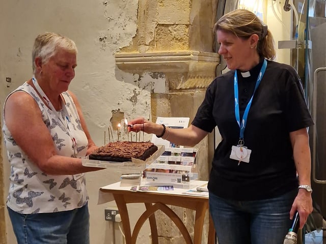 Vicar, the Rev Natalie Bawcutt, lighting the birthday cake