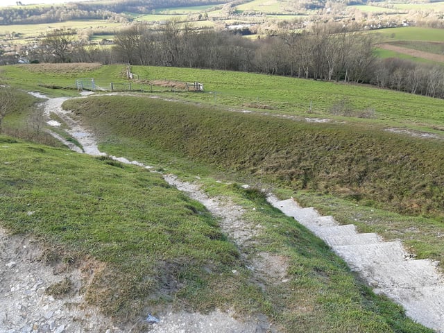 Once you have walked on a bit, the concrete steps become obvious. Take these down to the gate.