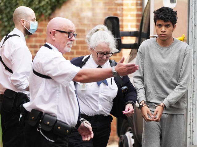 A Sussex teenager accused of murdering his father and attempting to kill a woman and a boy has been pictured arriving at court in handcuffs.