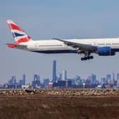 A Boeing 777 passenger aircraft of British Airways arrives from London at JFK International Airport in New York as the Manhattan skyline looms in the background on February 7, 2024. (Photo by Charly TRIBALLEAU / AFP) (Photo by CHARLY TRIBALLEAU/AFP via Getty Images)